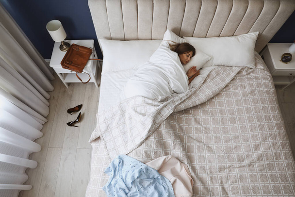 Mulher cansada dormindo na cama em casa depois do trabalho, acima da vista - Foto, Imagem