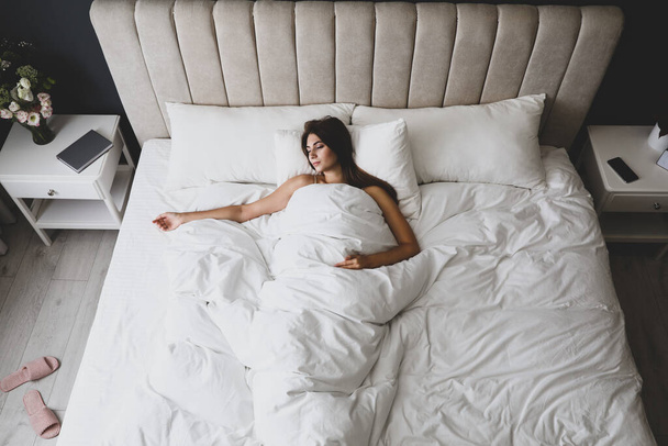 Mujer cansada durmiendo en la cama en casa, arriba de la vista - Foto, imagen