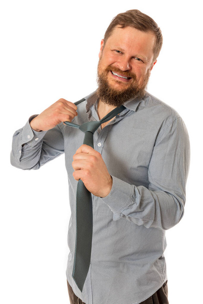 Cheerful bearded man dressed in shirt rips off his tie - Zdjęcie, obraz