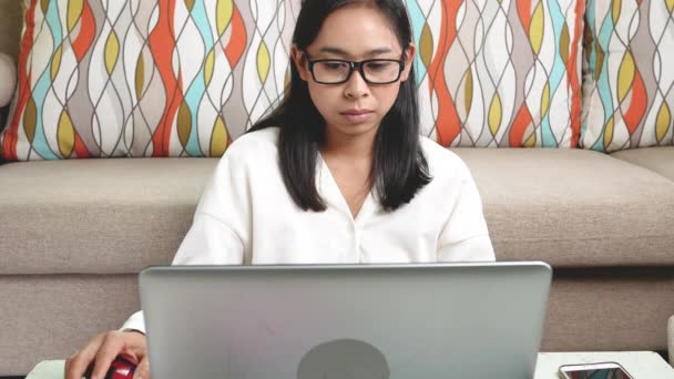 疲れた若い女性は痛みの目の疲れを感じ、ノートパソコンを使用して自宅のオフィスで作業中に乾いたいらいらした目をこすり. - 映像、動画