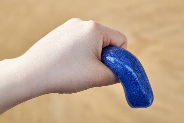 A toy made of soft plasticine in the hand of a woman, the theme of sexual dysfunctions, the toy symbolizes the penis - Foto, Imagen