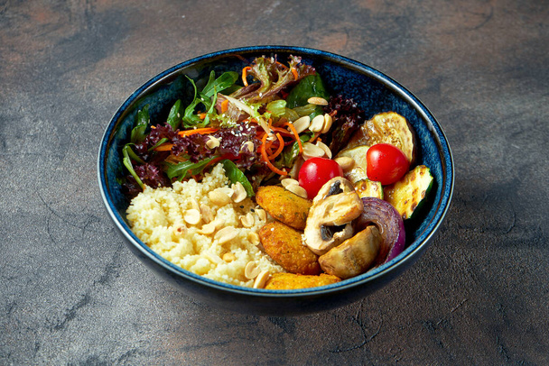 Buddha bowl with falafel, couscous, grilled vegetables in a blue plate. Selective focus - Fotoğraf, Görsel