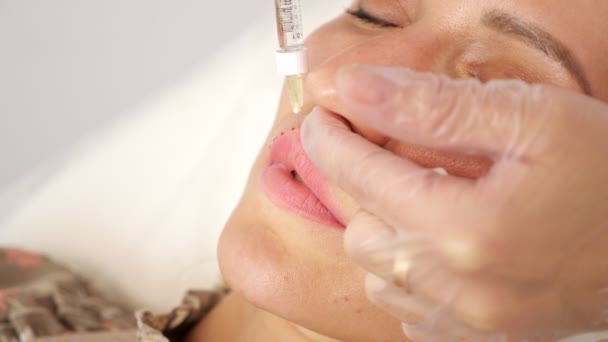 Dokter die een injectie in de lippen van een vrouw geeft - Video