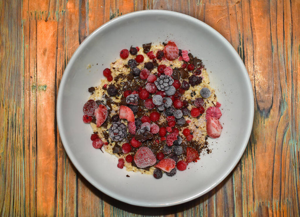 Bowl of oatmeal pudding with chocolate and berries. - Photo, Image