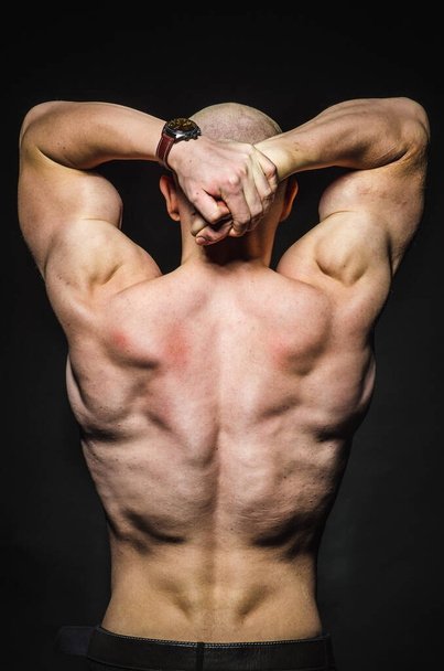 Sporty sexy man stands Topless on a dark background. Sports, beauty - Valokuva, kuva