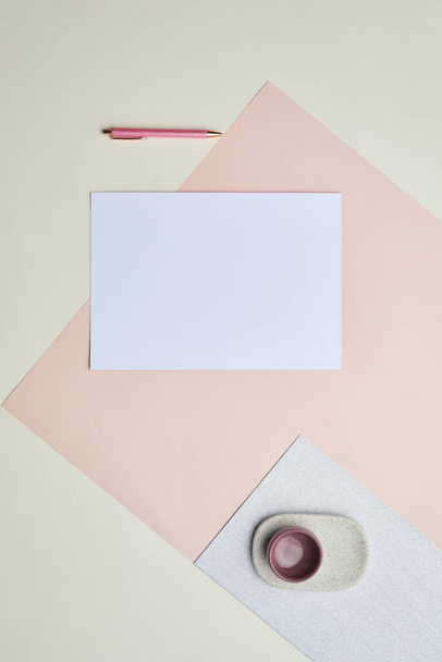 Composición gráfica mínima del papel blanco en blanco sobre fondo de color pastel, espacio de copia - Foto, imagen