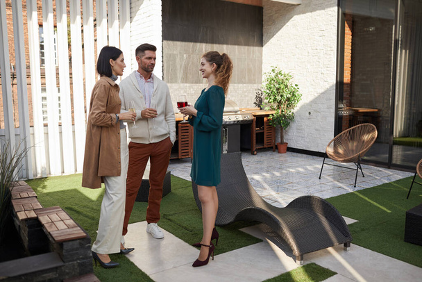 Full length portrait of contemporary adult people chatting while standing at outdoor terrace during party, copy space - Foto, Imagem