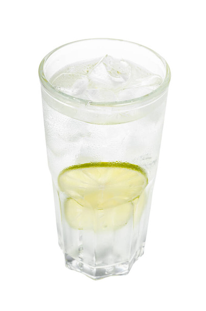 джин-тонизирующий коктейль в бокале хайбол с двумя ломтиками лайма и кубиками льда на белом фоне - Фото, изображение