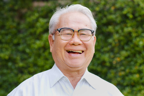 Portret gelukkig aziatische senior man kijken naar camera dan glimlachen en lachen - Foto, afbeelding