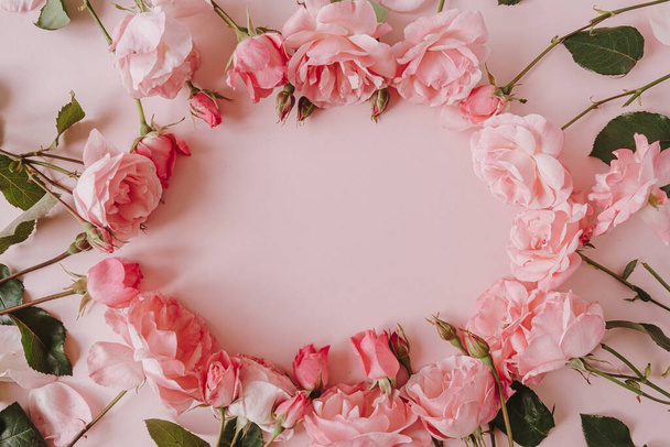 Valentine's Day / Mother's Day greeting card mockup. Frame wreath with empty blank copy space. Beautiful pink roses flowers on pink background. Flat lay, top view minimalistic floral composition. - Photo, Image