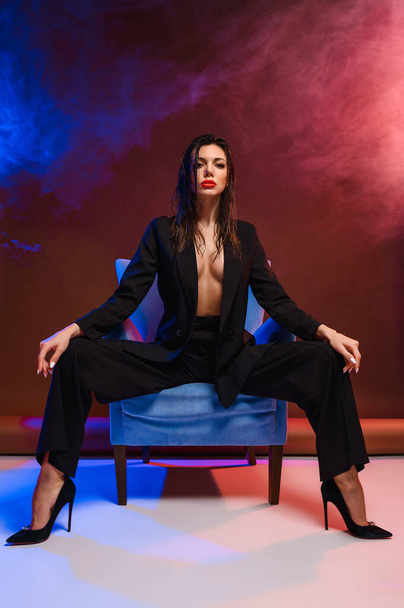 Attractive business woman in a business suit on an armchair - Foto, Imagem