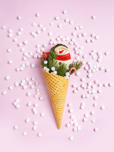 Snowman, marshmallows, Christmas tree twigs and lollipops in a waffle cone. Pink background. Christmas card. An original sweet gift. - Fotoğraf, Görsel