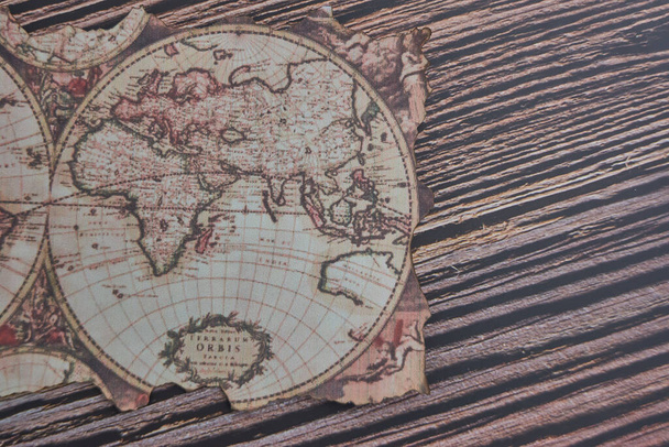 A top view on an old ancient map of the world placed on a wooden table - Фото, зображення