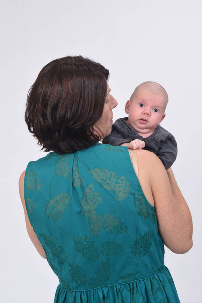 rear view of a mother with her baby on white background - Foto, Imagem