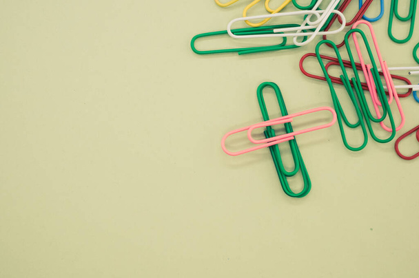 A closeup shot of multicolored paper clips on a piece of paper - 写真・画像