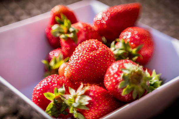 A closeup shot of ripe strawberries in a small bowl - Foto, afbeelding