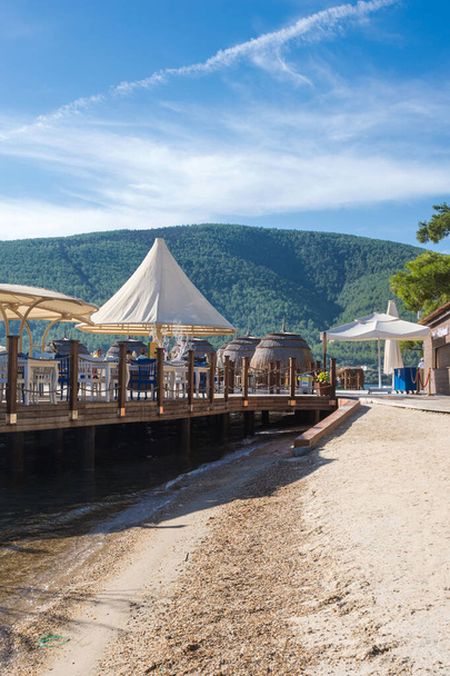 Hindi, Bodrum, Ekim 2020. Şemsiyeler ve sahildeki balık restoranının masaları. Türkiye 'de dinlenme. - Fotoğraf, Görsel