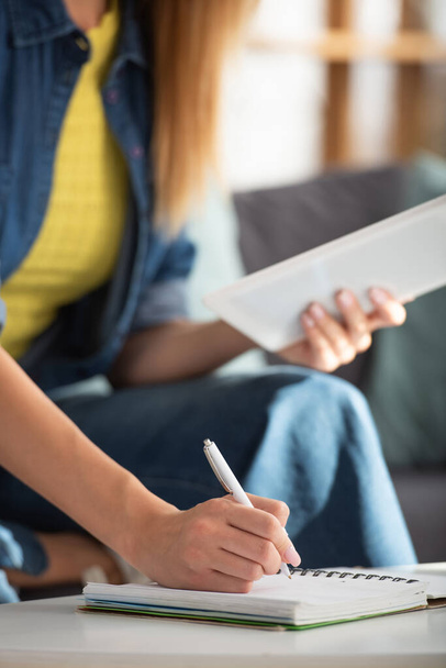 Vágott kilátás fiatal nő digitális tabletta írás notebook otthon homályos háttér - Fotó, kép
