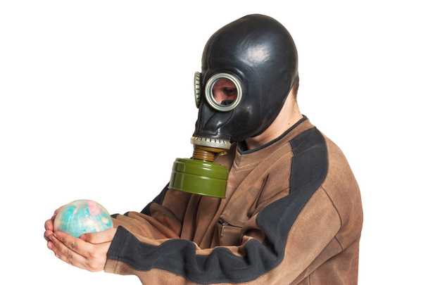 Young man in a gas mask holding a globe - Fotografie, Obrázek