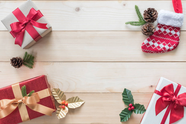 Рождественский фон с подарочной коробкой, красной атласной лентой и еловой веточкой украшения на белом столе из сосны на день бокса, зимний сезонный праздник и празднование Нового года - Фото, изображение