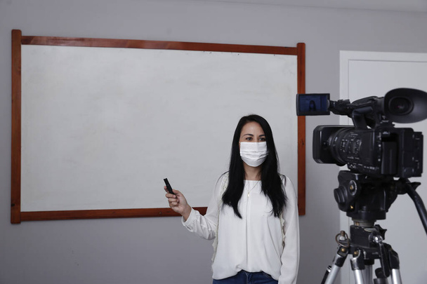 Docent met ademhalingsbescherming masker tijdens de presentatie van online virtuele klasse - Foto, afbeelding
