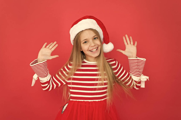 Happy new year. Happy child dressed as santa. Little santa girl happy smiling on red background. Happy holidays greeting. Christmas and new year - Photo, Image