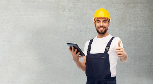 worker or builder with tablet pc showing thumbs up - Foto, Bild