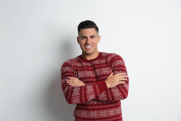 Happy man in Christmas sweater on white background - Fotó, kép