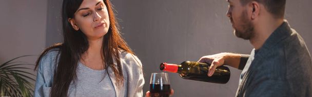 σύζυγος ρίχνει κόκκινο κρασί στο ποτήρι της συζύγου, banner - Φωτογραφία, εικόνα