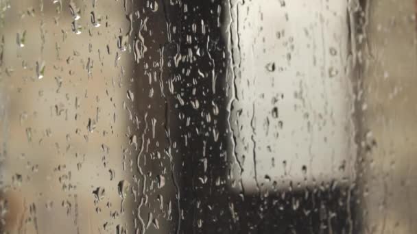Σταγόνες βροχής τρέχουν στο τζάμι του παραθύρου. Συννεφιασμένος βροχερός καιρός - Πλάνα, βίντεο