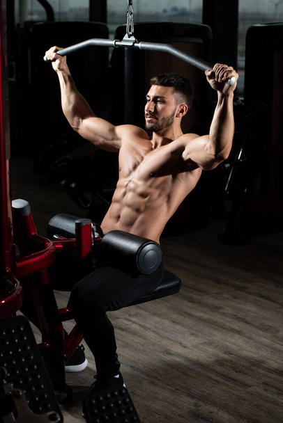 Handsome Athlete Doing Heavy Weight Exercise For Back On Machine - Valokuva, kuva