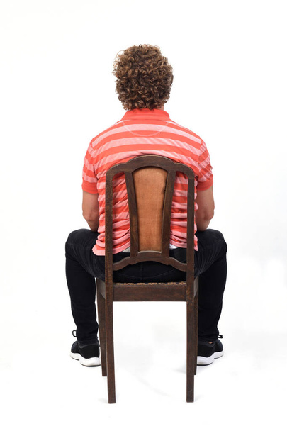 visão traseira de cheio um retrato de um homem encaracolado sentado no fundo branco, - Foto, Imagem