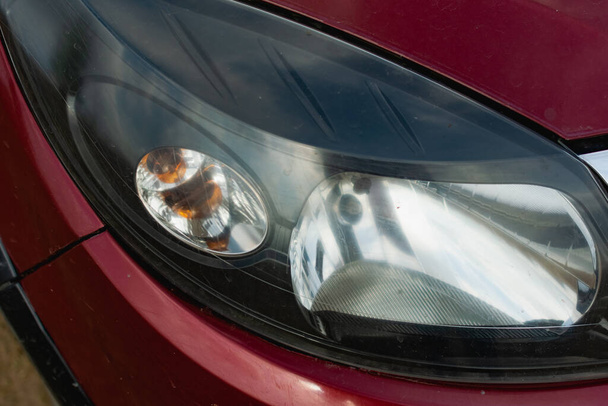 Large car headlights close-up, technical road lighting day and night. Front and rear colored lights and turn signals - Foto, afbeelding