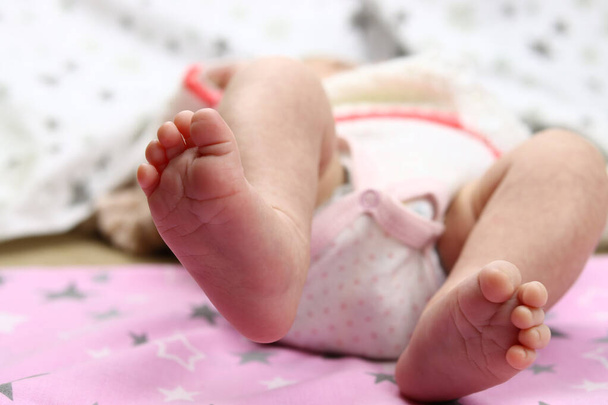 Cute feet of newborn baby on the blanket. The concept of love, health and care - Photo, Image