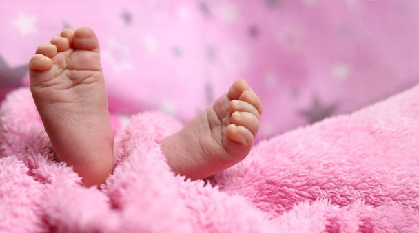 Ευαίσθητα πόδια μωρού στο κάλυμμα του κρεβατιού - Φωτογραφία, εικόνα