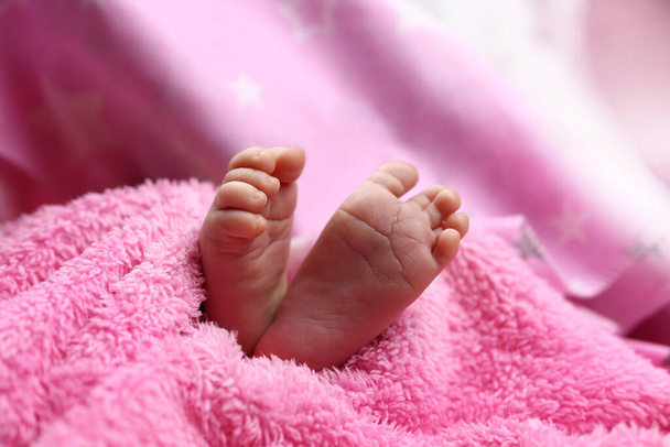 Χαριτωμένα πόδια νεογέννητου μωρού στην κουβέρτα. Η έννοια της αγάπης, της υγείας και της φροντίδας - Φωτογραφία, εικόνα