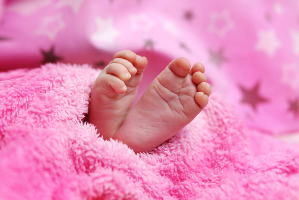 Χαριτωμένα πόδια νεογέννητου μωρού στην κουβέρτα. Η έννοια της αγάπης, της υγείας και της φροντίδας - Φωτογραφία, εικόνα