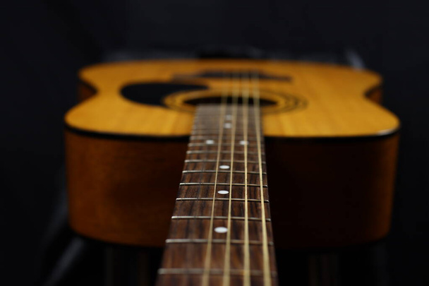 Κλασσική ξύλινη ακουστική κιθάρα closeup, σε μαύρο φόντο, ροκ, κάντρι μουσική έννοια - Φωτογραφία, εικόνα