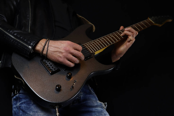 Gitarist siyah arka planda elektro gitar solosu çalıyor. - Fotoğraf, Görsel