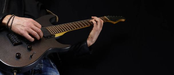 guitarist plays an electric guitar solo with a pick - Photo, Image