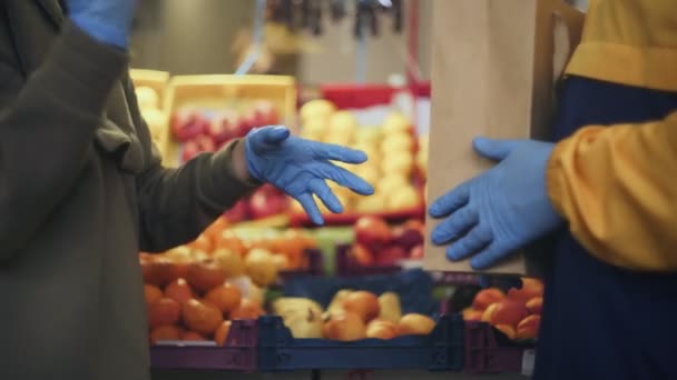 Primer plano de pareja joven en guantes azules peleando en el mercado - Metraje, vídeo