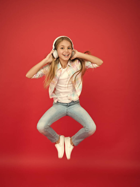 hipster kid keep moving. energetic child dancing. happy childhood. inspired with music. spring holiday time. girl celebrating victory. small girl in earphones. fun in motion. small rock star - Foto, Imagem