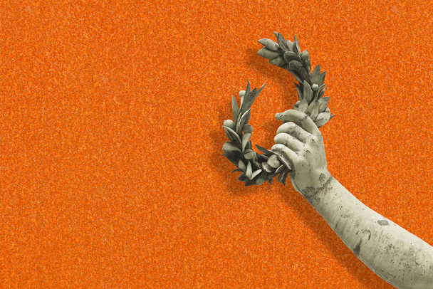 Hand holds a laurel wreath - concept image against a rusty metal background - Success and fame concept image with copy space. - Photo, Image