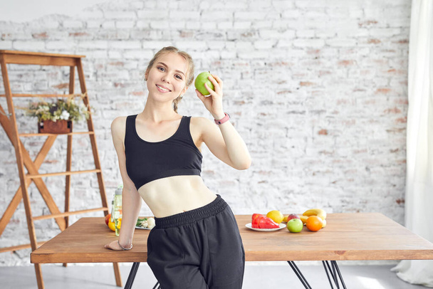 Sportive woman holding tasty apple. Concept of healthy organic food vitamin food. - Photo, image