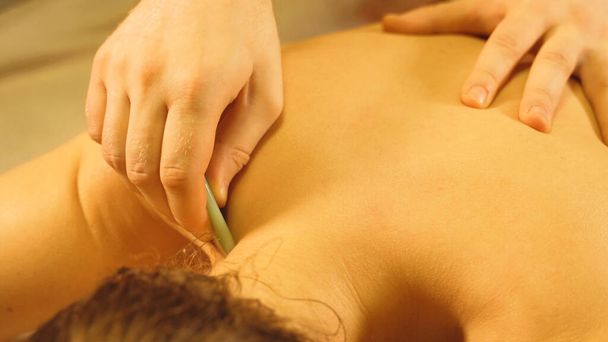 Massage master making gua sha massage. Spa and massage concept. - Photo, Image