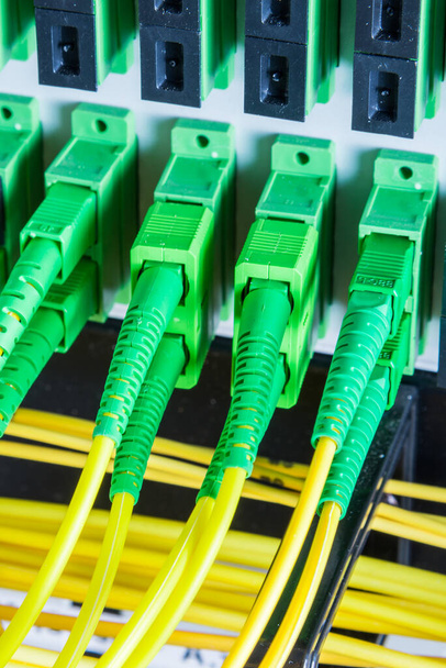 câbles à fibre optique branchés au panneau de commutation réseau à l'intérieur du centre de données - Photo, image