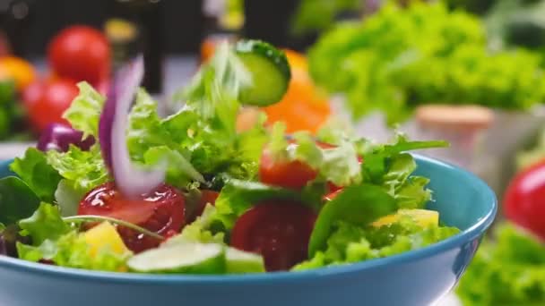 レタスの葉とトマトがボウルに落ちる新鮮なサラダ,白いテーブルの上に健康的な食品成分で提供,スローモーション - 映像、動画