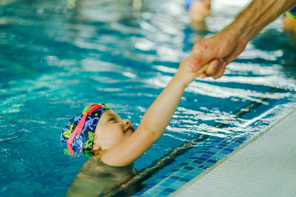 Entraînement de natation pour tout-petits dans la piscine. Formation à la natation pour un enfant. Développement du sport pour enfants. Renforcer la santé du bébé. - Photo, image