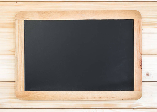 Blank black chalkboard frame with copyspace hanging on pine wood wall for announcement and restaurant menu - Photo, Image