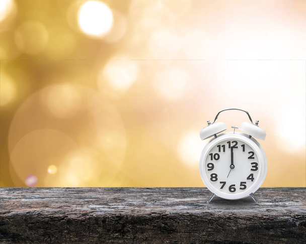 Daylight saving time end concept with alarm clock on yellow gold autumn blur background - Photo, Image
